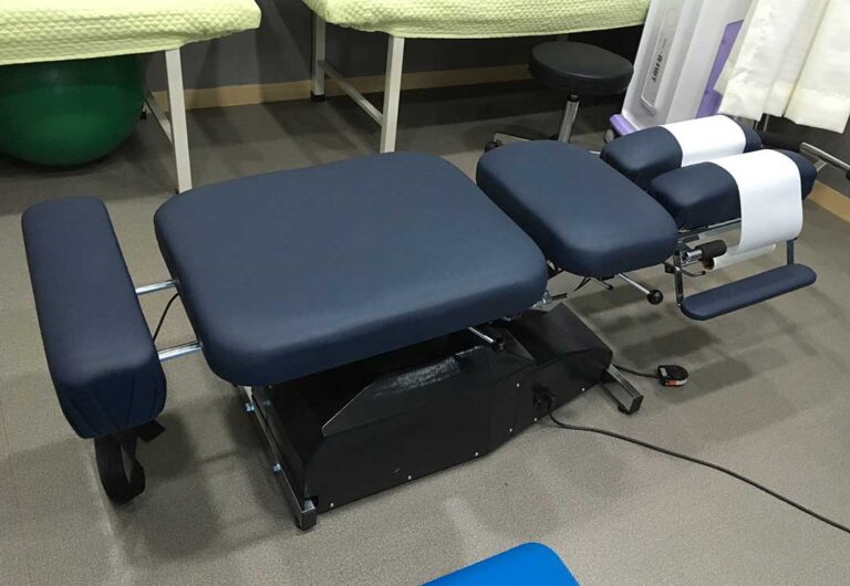 A chiropractor gently examining a young woman’s back and spine in a bright clinical setting.